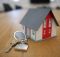 white and red wooden house miniature on brown table